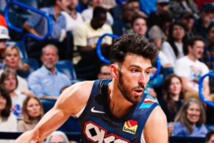 Chet Holmgren #7 of the Oklahoma City Thunder dribbles a basketball with his right hand while driving toward the basket. He is wearing the team's dark blue City Edition uniform.