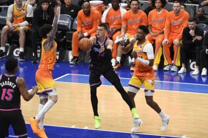 Miami Heat guard Tyler Herro (14) makes a pass while being defended by Charlotte Hornets players during an NBA game at Spectrum Center.