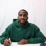 Josh Johnson signing a contract.