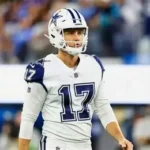 A professional football player for the Dallas Cowboys wearing a white jersey with the number 17 and a matching white helmet with a blue star logo, standing on the field during a game