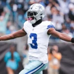A vertical action shot of George Pickens playing for the Dallas Cowboys. He is wearing the team's white jersey with navy blue stripes on the sleeves and the number "3" prominently displayed in blue.