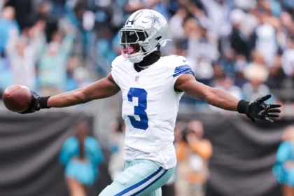 A vertical action shot of George Pickens playing for the Dallas Cowboys. He is wearing the team's white jersey with navy blue stripes on the sleeves and the number "3" prominently displayed in blue.