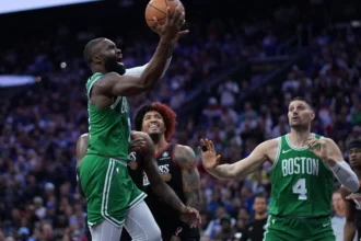Boston Celtics’ Jaylen Brown, left, goes up for a shot past Philadelphia 76ers’ Kelly Oubre Jr. during the first half of Game 3 in a first-round NBA playoffs basketball series Friday, April 24, 2026, in Philadelphia. (AP Photo/Matt Slocum)