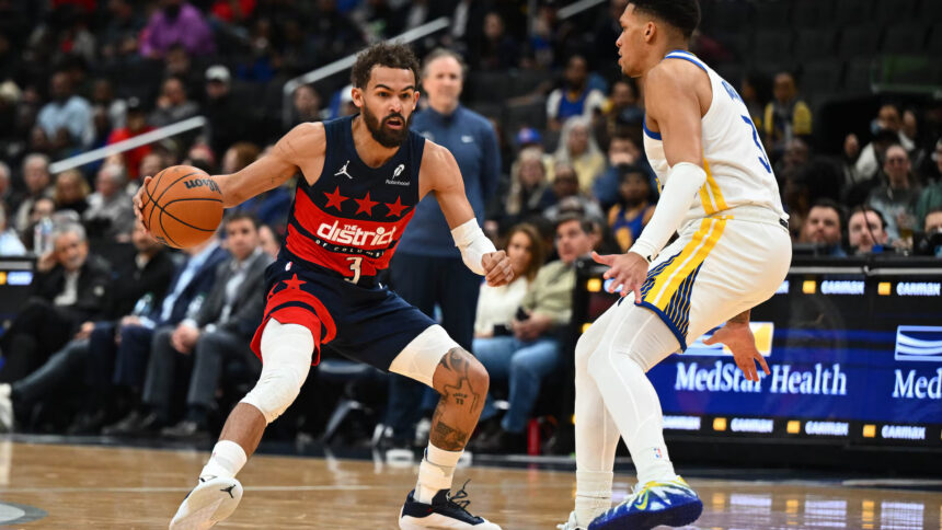 Washington Wizards guard Trae Young (3) dribbles as Golden State Warriors guard Will Richard (3) defends during the first half at Capital One Arena