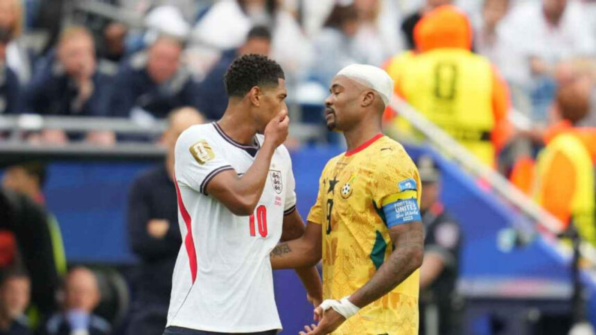 Bellingham covers his mouth while speaking to Ayew