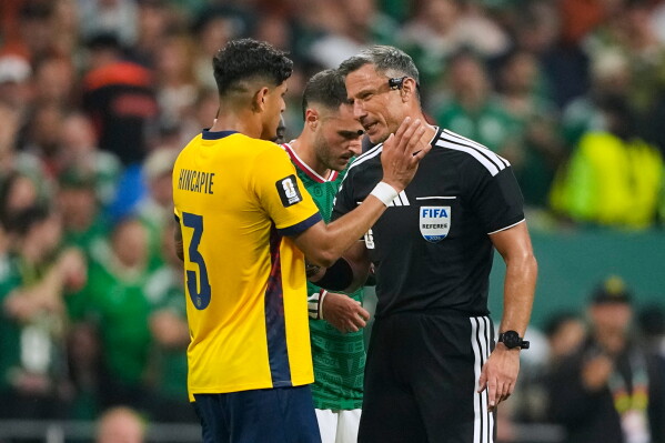 Referee Slavko Vincic of Slovenia talks to Ecuador's Piero Hincapie during the World Cup round of 32 match between Mexico and Ecuador in Mexico City. 