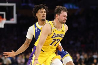 Luka Doncic #77 of the Los Angeles Lakers dribbles past the defense of Yaxel Lendeborg #1 of the Golden State Warriors during the first half of an NBA game at Crypto.com Arena on October 21, 2026 in Los Angeles, California..